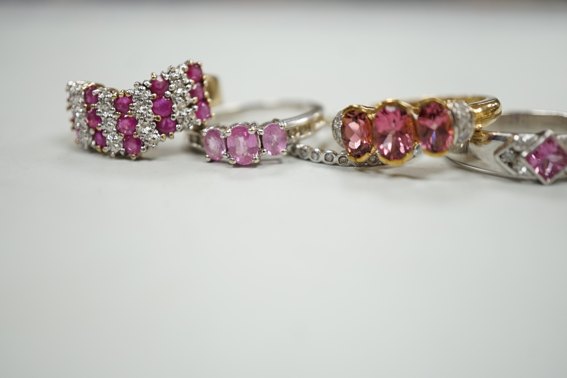 Five assorted modern 9ct gold and gem set dress rings, gross weight 16.7 grams and one other white metal and gem set eternity ring.